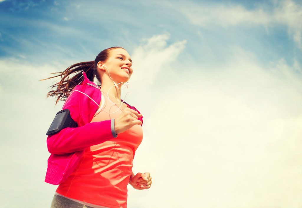 35172316 - fitness, sport and lifestyle concept - smiling young woman with earphones running outdoors